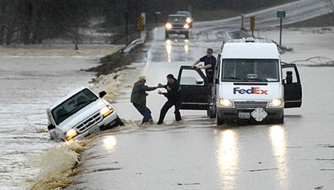 1999 Ford Ranger - A white Ford Ranger is stuck in floodwaters on a road, with assistance from a FedEx van and its driver.