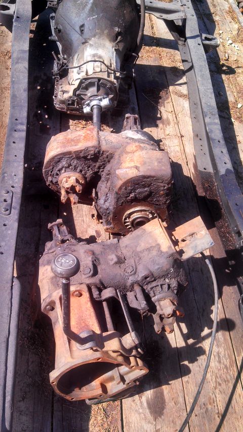 1979 Ford Bronco - A heavily used transmission and transfer case assembly is shown, resting on wooden planks.