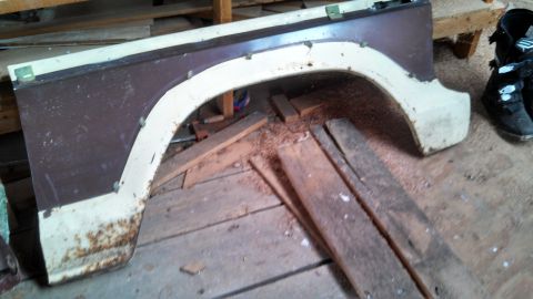 1979 Ford Bronco - This is a brown and white fender section, likely from a truck or SUV, showing signs of rust and wear.