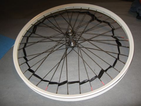 1994 Ford Bronco - A close-up view of a bicycle wheel with black tape applied to some of its spokes.