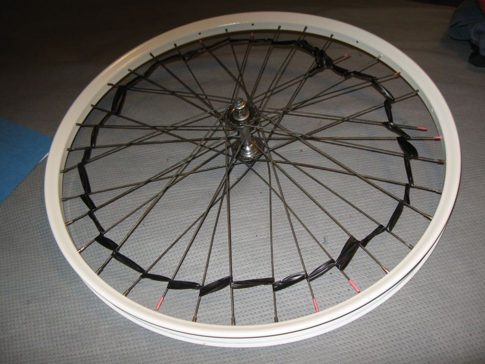 bicycle wheel with black tape wrapped around spokes