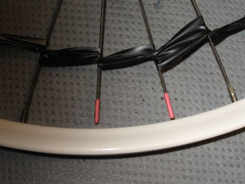 1994 Ford Bronco - Close-up of a bicycle wheel showing spokes bound with black tape and pink valve stem covers.