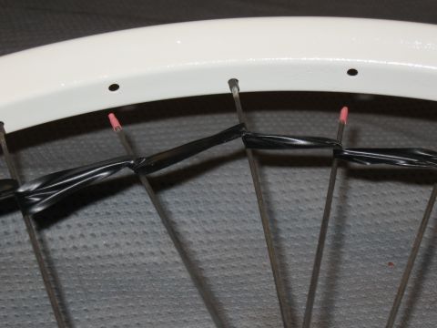 1994 Ford Bronco - Close-up of bicycle wheel spokes, some of which are wrapped with black electrical tape.