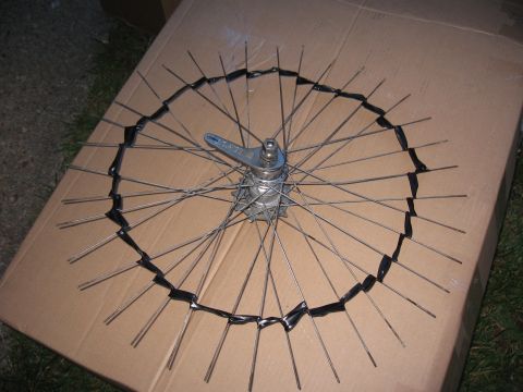 1994 Ford Bronco - A bicycle wheel is placed on a cardboard box, with some spokes taped to the surface.