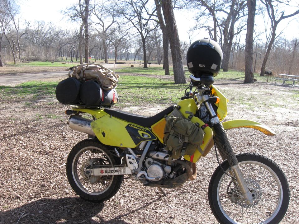 2006 Suzuki DR-Z400S dual-sport motorcycle loaded with camping gear and a helmet