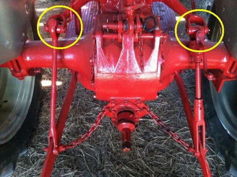 1963 Hummer H3 - This image shows the rear axle assembly of a red tractor, with PTO shafts circled.