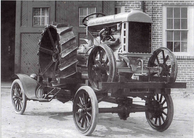 Tractor with large rear wheel and smaller front wheels, black and white photo