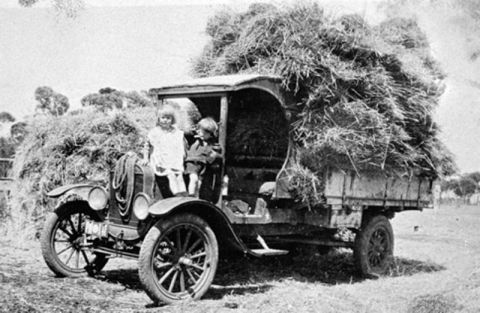 1909 Ford Model T - Children ride in the cab of a 1909 Ford Model T truck piled high with hay.