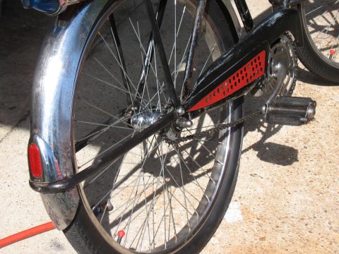 1994 Ford Bronco - Close-up of a bicycle's rear wheel and chain guard, showing chrome and red accents.