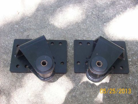 1982 Ford F-100 - Two black engine mounts with rubber bushings are shown on a concrete surface.