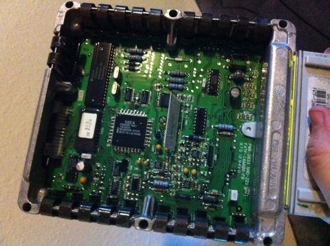 1992 Ford F-150 - Overhead shot of a Ford EEC engine control module with the cover off, showing the green board silk-screened "PWB-2833 SMD-221 / F4TF-14A060…