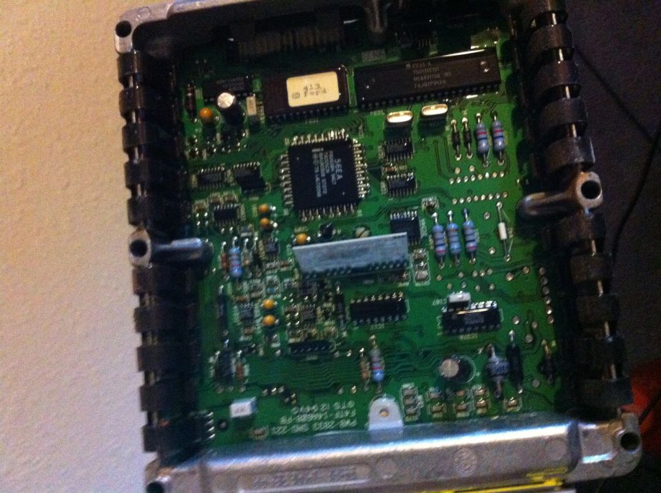 Opened Ford EEC engine computer showing green circuit board and 413 Ford EPROM label