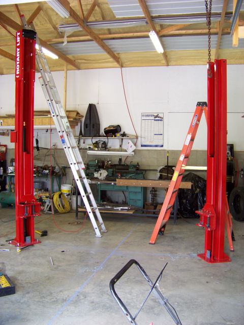 1974 Dodge Challenger - Interior view of a garage two red rotary lifts and several ladders, with tools and equipment visible in the background.