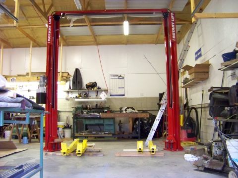 1974 Dodge Challenger - A workshop scene shows a red rotary lift with various tools and equipment in the background.