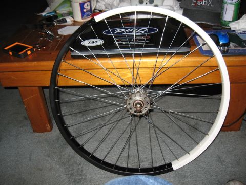 1994 Ford Bronco - A bicycle wheel is shown with a two-tone rim and many spokes.