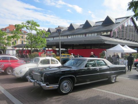 1991 Ford LTD Crown Victoria - Several classic cars are parked in front of a building with a distinctive roofline.