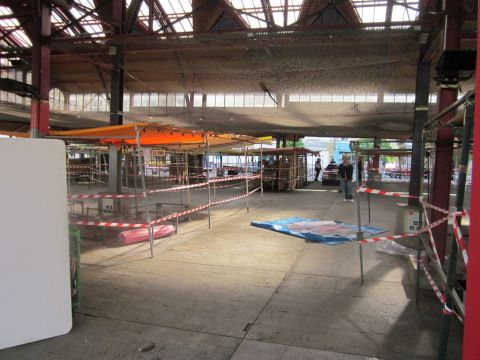 1991 Ford LTD Crown Victoria - A wide view of an indoor market with stalls and a red car parked in the background.