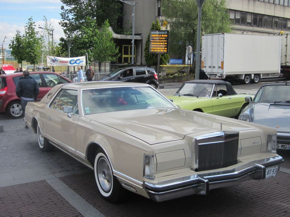Tan 1977 Lincoln Continental Mark V coupe parked on street, with other cars and buildings in background