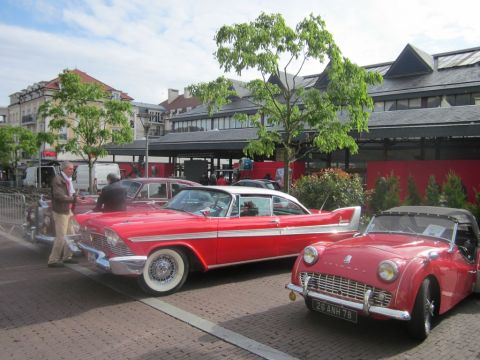 1991 Ford LTD Crown Victoria - A red and white 1957 Plymouth Belvedere hardtop is parked alongside other classic cars.