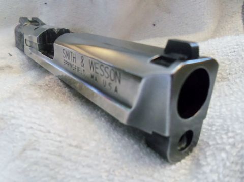 2000 Mercury Grand Marquis - A close-up view of a Smith & Wesson pistol slide, showing the barrel opening and manufacturer's markings.