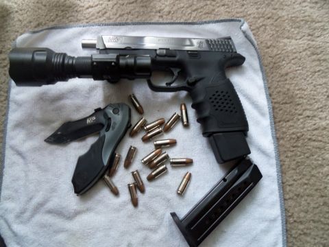 2000 Mercury Grand Marquis - Pistol, knife, and ammunition laid out on a towel.