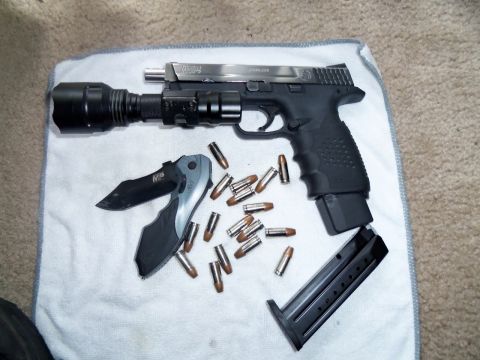 2000 Mercury Grand Marquis - A Smith & Wesson M&P pistol, knife, and ammunition are laid out on a towel.