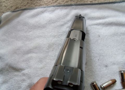 2000 Mercury Grand Marquis - A 9mm handgun is shown from the top, resting on a white cloth. The caliber marking is clearly visible on the slide.