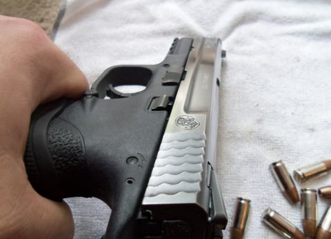 2000 Mercury Grand Marquis - Close-up of a handgun and ammunition, held by a person's hand.