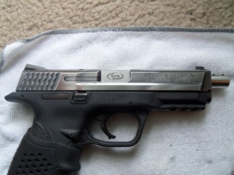 2000 Mercury Grand Marquis - A close-up view of a Smith & Wesson pistol, showing its two-tone construction and engraved details.
