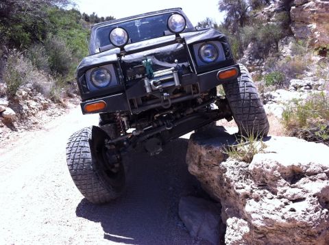 1987 Suzuki Samurai - This 1987 Suzuki Samurai navigates a rocky trail with its front tire on a boulder.