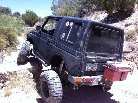 1987 Suzuki Samurai - Suzuki Samurai tackling a challenging rocky trail with its suspension articulated.