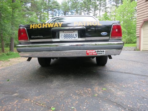 1991 Ford LTD Crown Victoria - Straight-on rear view of a black Ford Crown Victoria cruiser with gold Highway Patrol lettering and a California 888849 plate.