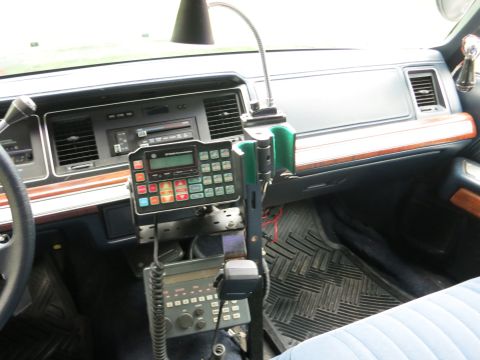 1991 Ford LTD Crown Victoria - Sedan dashboard fitted with a numeric-keypad two-way radio control head and a handheld mic on a center mounting stand.