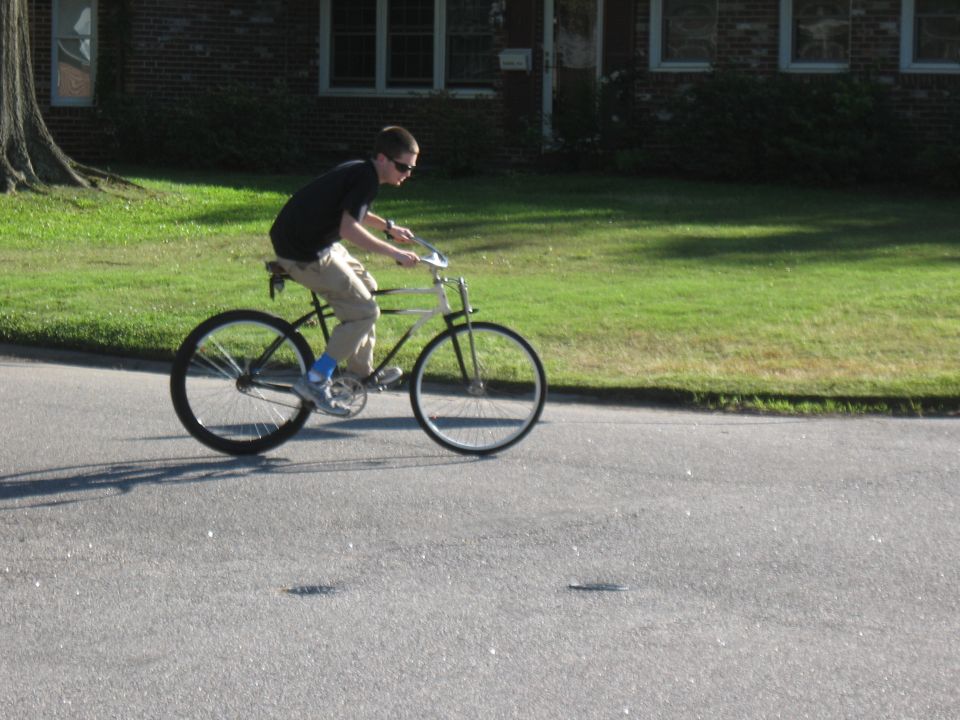 Guy on a vintage-style bicycle riding down a street