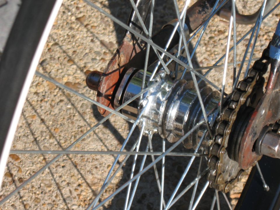 Close-up of a bicycle's chrome hub and chain
