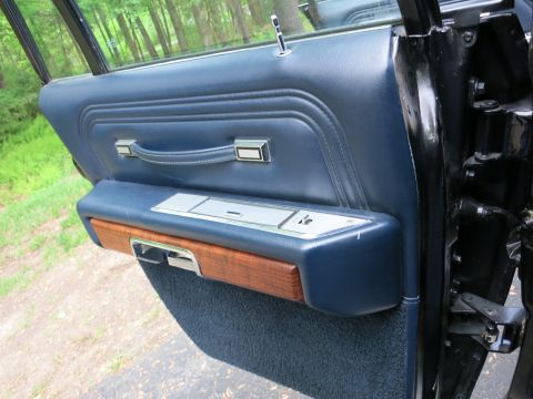 1991 Ford LTD Crown Victoria - Open car door showing a blue upholstered panel with woodgrain trim, pull handle and chrome accents.