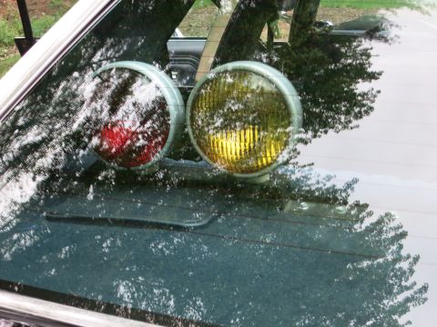 1991 Ford LTD Crown Victoria - red and an amber round spotlight mounted on a dashboard, viewed through a car's windshield.