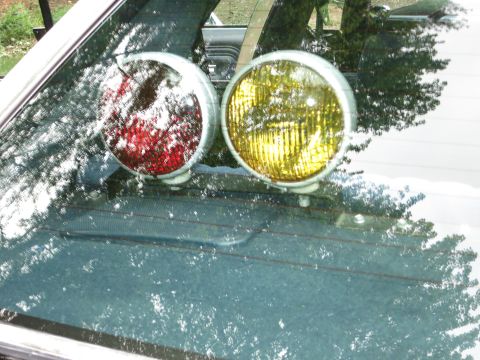 1991 Ford LTD Crown Victoria - Close view through a windshield of paired red and amber round lights mounted on the dashboard.