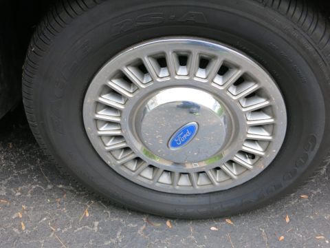 1991 Ford LTD Crown Victoria - Ford-badged turbine-style alloy wheel fitted with a Goodyear Eagle RS-A tire on a dark car.