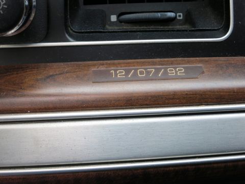 1991 Ford LTD Crown Victoria - Close-up of a woodgrain dash trim panel with a small brass plate engraved 12/07/92.