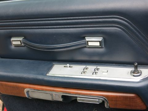 1991 Ford LTD Crown Victoria - Interior car door panel in blue with chrome window switches, a horizontal pull handle and woodgrain accent.