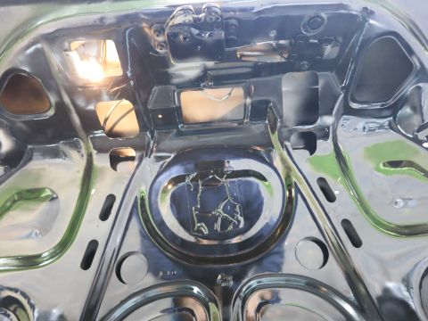 1991 Ford LTD Crown Victoria - Underside of a glossy black trunk lid showing bare painted sheet-metal stampings and reinforcement ribs.