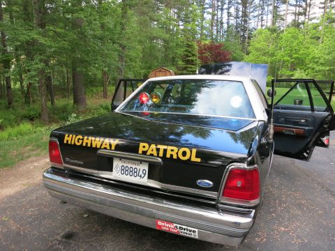 1991 Ford LTD Crown Victoria - Rear three-quarter view of a black-and-white Ford Crown Victoria marked Highway Patrol with rear door open and deck lights.