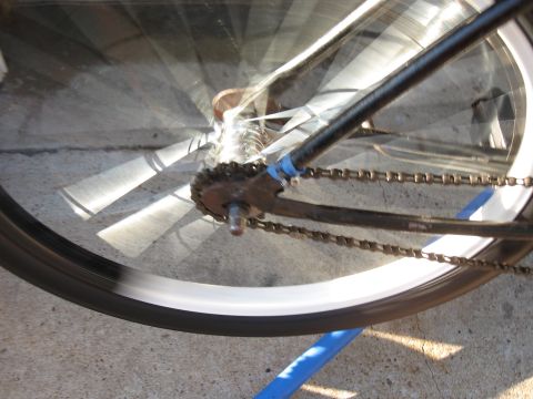 1994 Ford Bronco - Close-up of a bicycle's rear wheel and chain, showing motion blur on the spokes and tire.