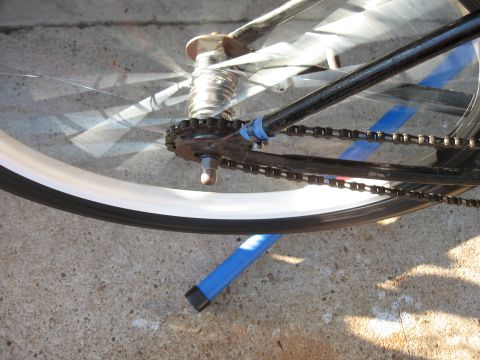 1994 Ford Bronco - Close-up view of a bicycle's rear wheel, chain, and gears, resting on a concrete surface.