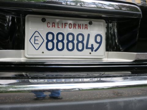 1991 Ford LTD Crown Victoria - Close-up of a white California license plate reading 888849 with a diamond E exempt marking on a black chrome bumper.