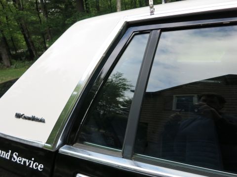 1991 Ford LTD Crown Victoria - Rear quarter window and C-pillar of a two-tone Grand Marquis sedan, with 'Grand Marquis' badge and 'and Service' lettering on the door.