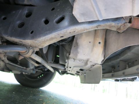 1991 Ford LTD Crown Victoria - Undercarriage view of a front control arm, sway bar link and inner fender liner of a vehicle.
