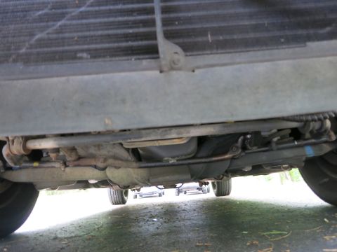 1991 Ford LTD Crown Victoria - Front undercarriage view showing the radiator core, crossmember, steering linkage and both front wheels.