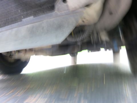 1991 Ford LTD Crown Victoria - Motion-blurred undercarriage shot showing the frame, floor pan and suspension of a vehicle.